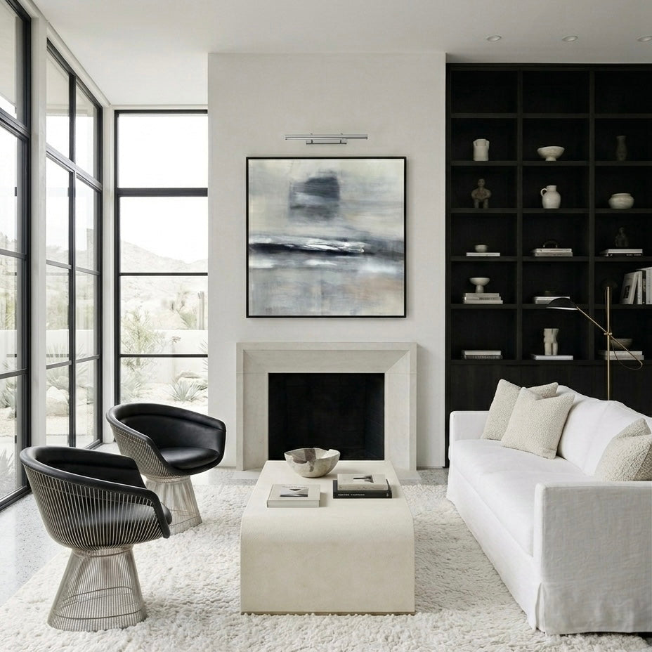 Modern living room with white sofa, black chairs, and a fireplace.